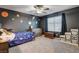 Stylish bedroom featuring a galaxy-themed wall, ceiling fan, and plush carpeting at 7828 Stone Forest St, North Las Vegas, NV 89084