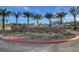 Community sign landscaped with gravel, mature palm trees, flowering shrubs and green ground cover at 7828 Stone Forest St, North Las Vegas, NV 89084