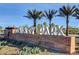 Community sign landscaped with gravel, mature palm trees, flowering shrubs and green ground cover at 7828 Stone Forest St, North Las Vegas, NV 89084