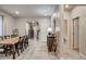 Bright dining room featuring a rustic wood table, six chairs, neutral paint, and tile floors at 7828 Stone Forest St, North Las Vegas, NV 89084