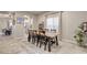 Open dining room with a rustic wood table, six chairs, and views of the kitchen and backyard at 7828 Stone Forest St, North Las Vegas, NV 89084