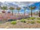 Stone entrance sign surrounded by desert landscaping and mature palm trees at 7828 Stone Forest St, North Las Vegas, NV 89084