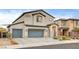 Two-story home featuring a three car garage, stucco siding, tile roof, and a desert landscape at 7828 Stone Forest St, North Las Vegas, NV 89084