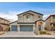 Two-story home featuring a three car garage, stucco siding, tile roof, and a desert landscape at 7828 Stone Forest St, North Las Vegas, NV 89084