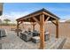 This backyard gazebo features a cozy seating area with a fire pit and outdoor fans at 7828 Stone Forest St, North Las Vegas, NV 89084