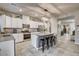 Spacious kitchen boasts white cabinets, granite countertops, stainless steel appliances, and island with seating at 7828 Stone Forest St, North Las Vegas, NV 89084