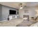 Open living room featuring tile floors, neutral paint, a ceiling fan, and a comfortable gray sectional at 7828 Stone Forest St, North Las Vegas, NV 89084