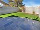 Private backyard featuring faux grass, a stone-tiled patio, and block wall fencing at 8032 Astrology Ct # 201, Las Vegas, NV 89128