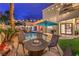 A backyard features a pool, spa, rock waterfall, and outdoor seating area under string lights at 8032 Marbella Cir, Las Vegas, NV 89128