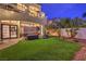 Lush backyard featuring a green lawn, mature landscaping, patio, and balcony view at 8032 Marbella Cir, Las Vegas, NV 89128