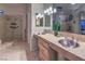 Bathroom featuring double sinks, a walk-in shower with glass door, and ample counter space at 8032 Marbella Cir, Las Vegas, NV 89128