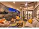 Relaxing covered patio featuring comfortable seating, a ceiling fan, and outdoor entertainment at 8032 Marbella Cir, Las Vegas, NV 89128