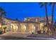 Elegant home exterior showcasing a three-car garage, meticulous landscaping, and warm lighting at 8032 Marbella Cir, Las Vegas, NV 89128