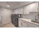 Bright laundry room boasts modern appliances, ample counter space, and sleek white cabinetry at 8032 Marbella Cir, Las Vegas, NV 89128
