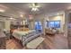 A spacious bedroom with wood floors, ceiling fan, and a king bed in front of mirrored wall decor at 8032 Marbella Cir, Las Vegas, NV 89128