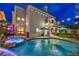 A backyard pool and spa, illuminated by string lights, with a built-in waterfall feature at 8032 Marbella Cir, Las Vegas, NV 89128