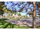 Outdoor community sand volleyball court surrounded by lush greenery and a lake, perfect for recreational activities at 8032 Marbella Cir, Las Vegas, NV 89128