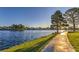 Picturesque lakeside view with a walking path, lush greenery, and serene waterfront homes at 8032 Marbella Cir, Las Vegas, NV 89128