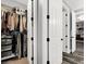 Walk-in closet and hallway featuring clothing racks, shelving, carpet and hardwood flooring, and doors at 8102 Villa De La Playa St, Las Vegas, NV 89131