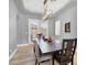 Elegant dining room featuring a modern light fixture, neutral decor, and access to the outdoor at 8102 Villa De La Playa St, Las Vegas, NV 89131