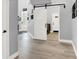 Hallway with a white barn door, decorative light fixtures, and wood-look tile flooring at 8102 Villa De La Playa St, Las Vegas, NV 89131