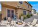 Charming outdoor patio area with a cozy fire pit, seating, and easy access to indoor/outdoor living through French doors at 8102 Villa De La Playa St, Las Vegas, NV 89131