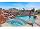 Sparkling pool with rock waterfall and attached spa, creating a serene backyard retreat for leisure and relaxation at 8102 Villa De La Playa St, Las Vegas, NV 89131