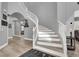 Elegant curved staircase with white railing and wood-look flooring at 8102 Villa De La Playa St, Las Vegas, NV 89131