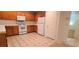 Kitchen features wooden cabinets, white appliances, and tile flooring at 8120 Finch Feather St, Las Vegas, NV 89143