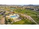 An aerial view of a community pool area with a pool, splash pad, seating, and walking paths at 827 Klamath Springs St, Henderson, NV 89011