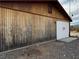 Weathered wooden structure with a boarded-up door and a vent near the roofline at 895 Greasewood Ln, Moapa, NV 89025