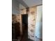 Hallway with dated wood paneling leading to another room in a state of disrepair at 895 Greasewood Ln, Moapa, NV 89025
