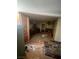 Interior view of a neglected kitchen with damaged walls, debris, and aged cabinetry at 895 Greasewood Ln, Moapa, NV 89025