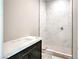Modern bathroom features marble shower, dark vanity with elegant quartz countertop, and neutral flooring at 9 Rue Grimaldi Way, Henderson, NV 89011