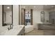 Luxurious bathroom featuring double vanity, freestanding tub, modern chandelier, and a large window at 9 Rue Grimaldi Way, Henderson, NV 89011