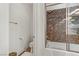 Bathroom with a shower and tub featuring granite surround and a glass door at 9050 W Tropicana Ave # 1102, Las Vegas, NV 89147
