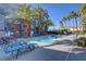 Community pool surrounded by palm trees and lounge chairs at 9050 W Tropicana Ave # 1102, Las Vegas, NV 89147