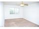 Bright bedroom featuring neutral carpet, a window, and a ceiling fan at 9672 Gunsmith Dr, Las Vegas, NV 89123