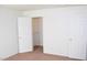 Bright bedroom featuring neutral walls, carpeted floors, walk-in closet and a traditional white door at 9672 Gunsmith Dr, Las Vegas, NV 89123