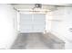 View of the empty two car garage with white walls, overhead storage, and concrete flooring at 9672 Gunsmith Dr, Las Vegas, NV 89123