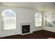 Bright living room featuring a fireplace and large arched windows at 9672 Gunsmith Dr, Las Vegas, NV 89123