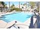 Sparkling community pool surrounded by lounge chairs, palm trees, and well-maintained landscaping at 9672 Gunsmith Dr, Las Vegas, NV 89123