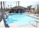 Inviting community pool area with palm trees, lounge chairs, and a well-kept clubhouse at 9672 Gunsmith Dr, Las Vegas, NV 89123