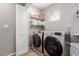 Laundry room with front load washer and dryer units, shelving, and a folding door at 11237 Gallery Echo St, Las Vegas, NV 89141