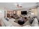 Open-concept living room and kitchen with tile flooring, ceiling fan and large sofa at 11237 Gallery Echo St, Las Vegas, NV 89141