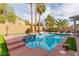 Sparkling pool with a lounge area, palm trees, and lush landscaping for ultimate relaxation and entertainment at 11237 Gallery Echo St, Las Vegas, NV 89141