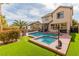 Backyard pool with a spa, surrounded by lush green landscaping, creating a private oasis at 11237 Gallery Echo St, Las Vegas, NV 89141
