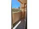 A sunny balcony offers views beyond the dividing wall of a parking area with carports under a bright blue sky at 1150 N Buffalo Dr # 1015, Las Vegas, NV 89128