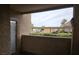 View from a balcony with a door in the foreground overlooking a parking area with carports beyond the dividing wall at 1150 N Buffalo Dr # 1015, Las Vegas, NV 89128