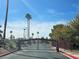 Gated community entrance with mature landscaping and palm trees against a blue sky at 1150 N Buffalo Dr # 1015, Las Vegas, NV 89128